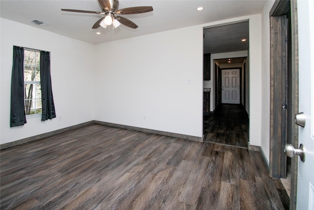 empty room with ceiling fan and dark hardwood / wood-style flooring