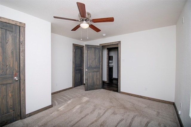 unfurnished bedroom featuring light colored carpet and ceiling fan