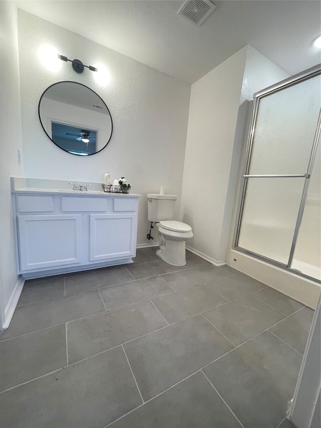 bathroom featuring tile patterned floors, vanity, toilet, and an enclosed shower