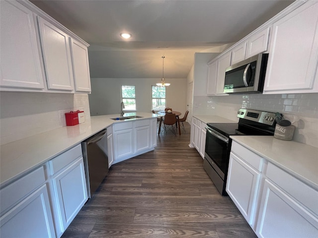 kitchen with sink, stainless steel appliances, an inviting chandelier, kitchen peninsula, and white cabinets