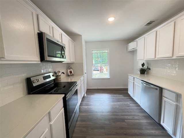 kitchen with white cabinetry, dark hardwood / wood-style flooring, tasteful backsplash, and appliances with stainless steel finishes