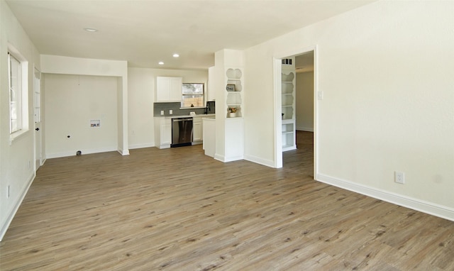 unfurnished living room with a wealth of natural light and light hardwood / wood-style flooring