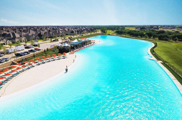 view of pool with a water view and a view of the beach