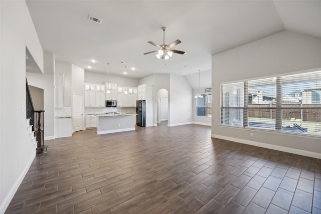 unfurnished living room with ceiling fan and lofted ceiling