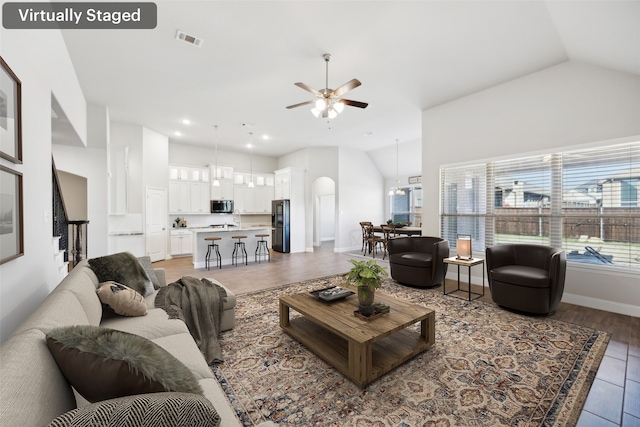 living room featuring hardwood / wood-style floors, ceiling fan, and lofted ceiling