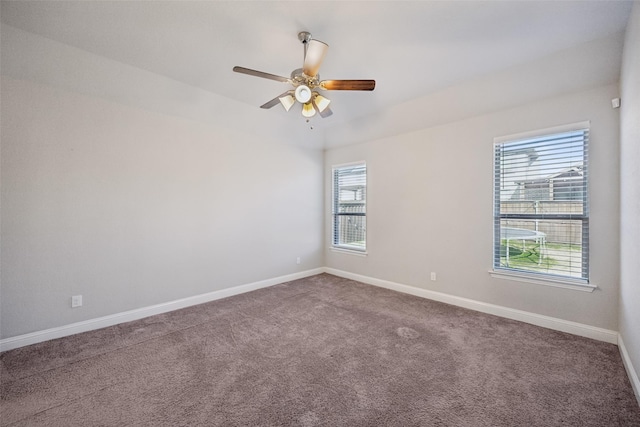 carpeted empty room featuring ceiling fan and a wealth of natural light