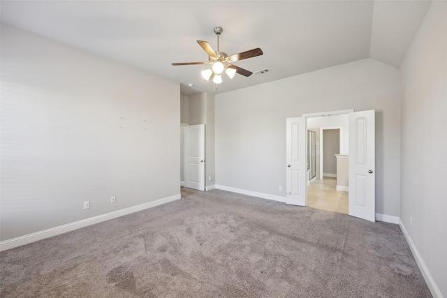 spare room featuring ceiling fan, light carpet, and lofted ceiling