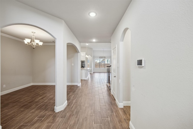 hall featuring ornamental molding and a chandelier