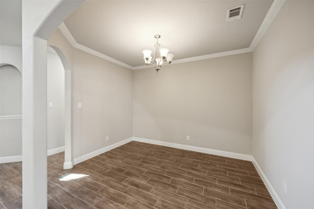 spare room featuring ornamental molding and an inviting chandelier