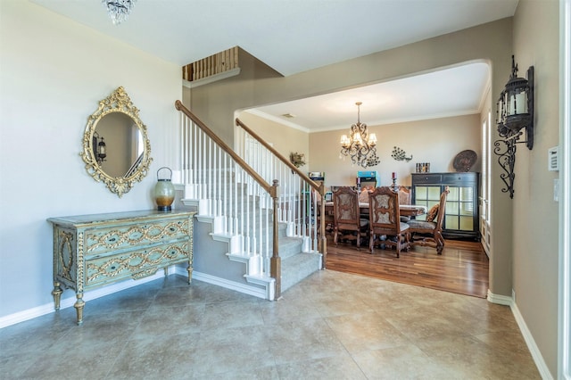 stairs featuring a notable chandelier, ornamental molding, and baseboards