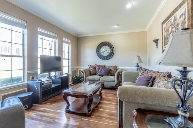 living room with wood-type flooring, a wealth of natural light, and ornamental molding