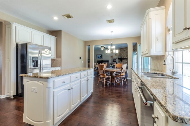 kitchen with stainless steel appliances, a kitchen island, and white cabinets