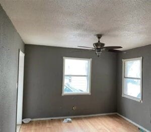 spare room featuring ceiling fan, light hardwood / wood-style flooring, and a textured ceiling