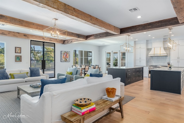 living area featuring light wood-type flooring, beam ceiling, visible vents, and a notable chandelier