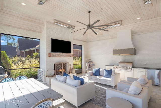 view of patio with ceiling fan, outdoor dining area, an outdoor kitchen, a grill, and an outdoor living space with a fireplace