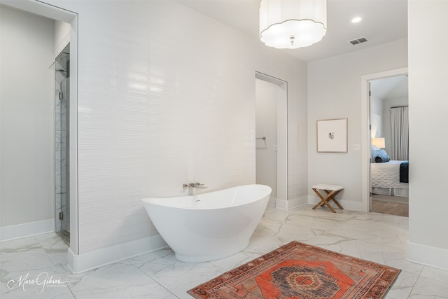 full bathroom with ensuite bathroom, visible vents, baseboards, a freestanding bath, and marble finish floor