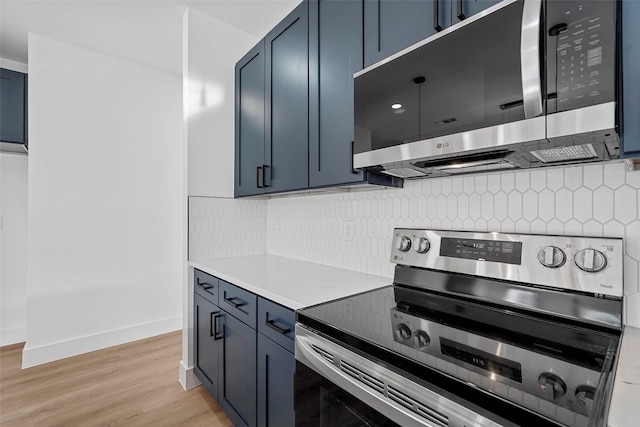 kitchen featuring blue cabinetry, decorative backsplash, light hardwood / wood-style floors, and appliances with stainless steel finishes