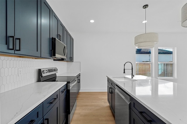 kitchen featuring decorative backsplash, light stone countertops, light wood-type flooring, decorative light fixtures, and stainless steel appliances