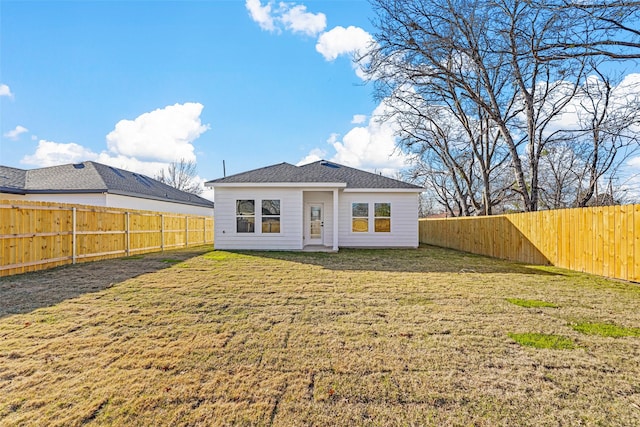 rear view of property featuring a yard