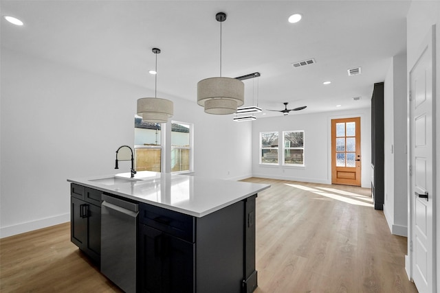 kitchen featuring pendant lighting, a kitchen island with sink, sink, ceiling fan, and light hardwood / wood-style floors