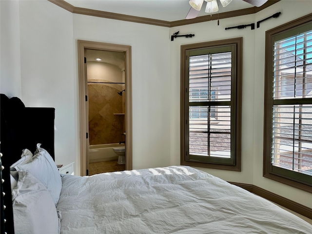 bedroom featuring ceiling fan, ensuite bathroom, and crown molding