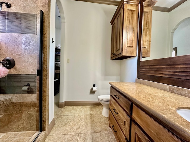 bathroom with an enclosed shower, vanity, tile patterned flooring, and toilet