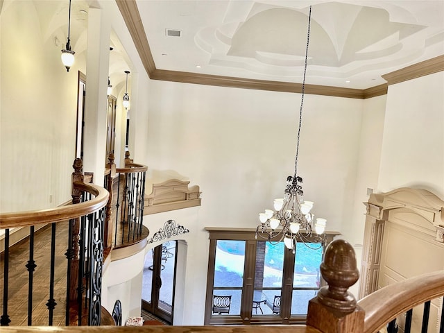 details with crown molding, a raised ceiling, french doors, and a notable chandelier