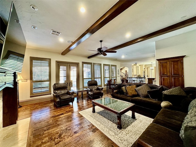 living room with ceiling fan, hardwood / wood-style flooring, french doors, and beamed ceiling