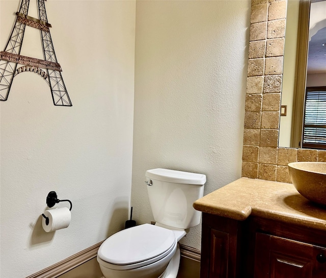 bathroom featuring toilet, vanity, and decorative backsplash