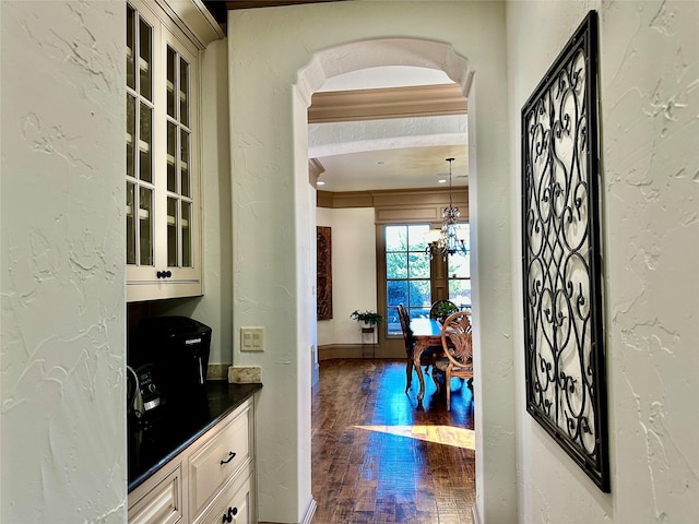 bar featuring a notable chandelier, hanging light fixtures, and cream cabinetry