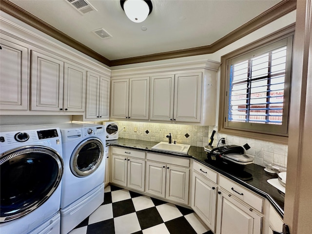 clothes washing area with cabinets, crown molding, independent washer and dryer, and sink