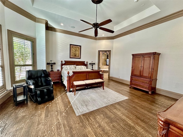 bedroom with ceiling fan, dark hardwood / wood-style floors, and a tray ceiling