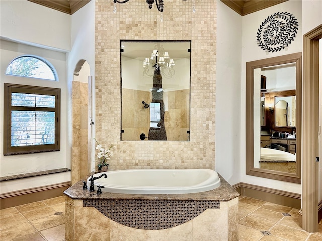 bathroom with tiled bath and ornamental molding