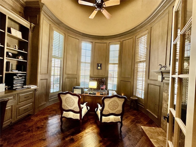 living area with ceiling fan, dark hardwood / wood-style flooring, crown molding, and built in features