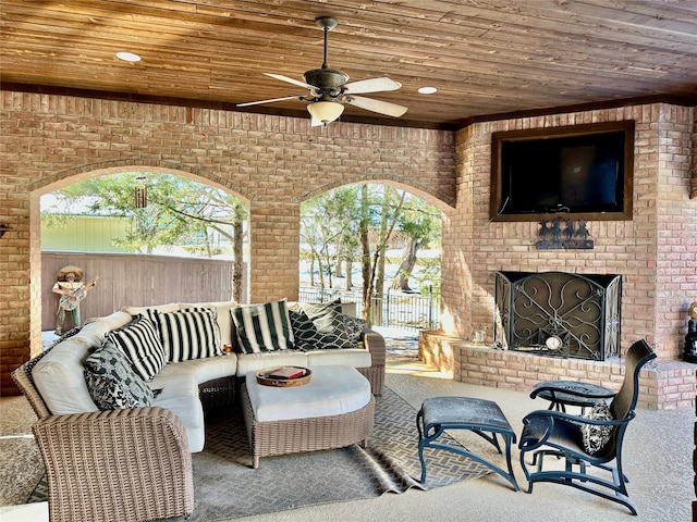 view of patio / terrace featuring ceiling fan and an outdoor living space with a fireplace