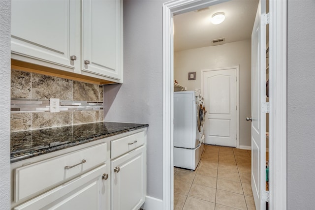 clothes washing area with washing machine and dryer and light tile patterned floors