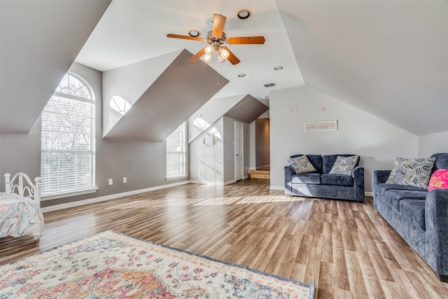 living room featuring a wealth of natural light, lofted ceiling, and light wood-type flooring