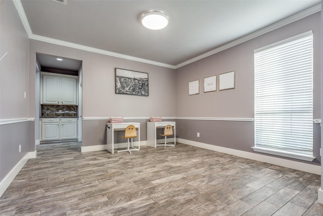 unfurnished office featuring light wood-type flooring and crown molding