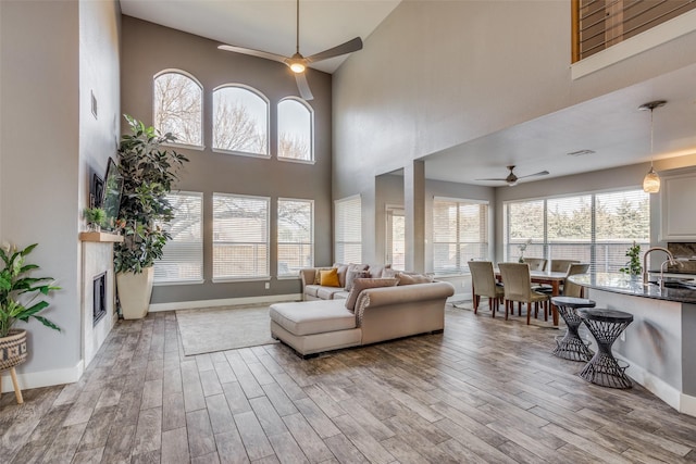 living room with a high ceiling, ceiling fan, and sink