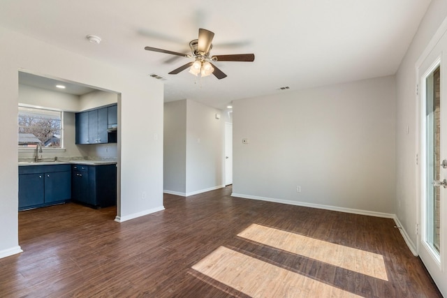 unfurnished living room featuring sink, ceiling fan, and dark hardwood / wood-style flooring