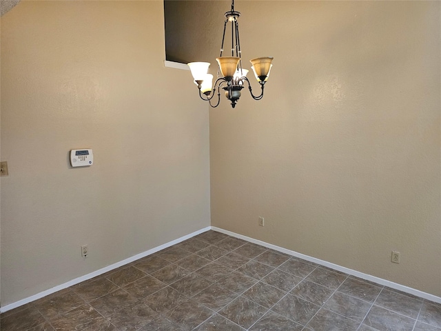 spare room featuring a chandelier