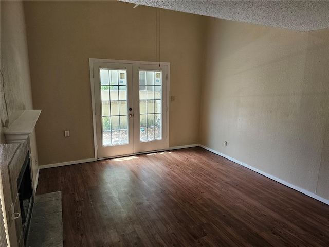 unfurnished living room with french doors, dark hardwood / wood-style flooring, and a textured ceiling