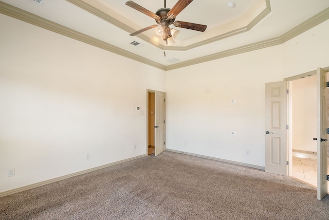 unfurnished room featuring ceiling fan, crown molding, a raised ceiling, and carpet