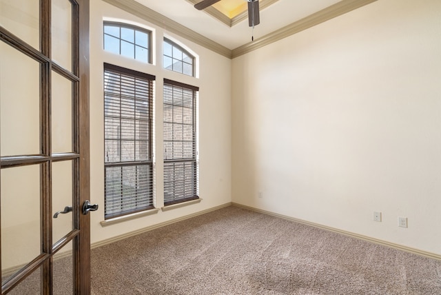 empty room with ceiling fan, crown molding, and carpet