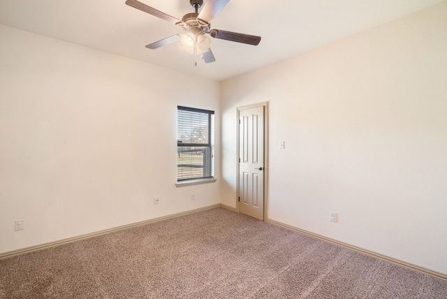 empty room featuring ceiling fan and carpet