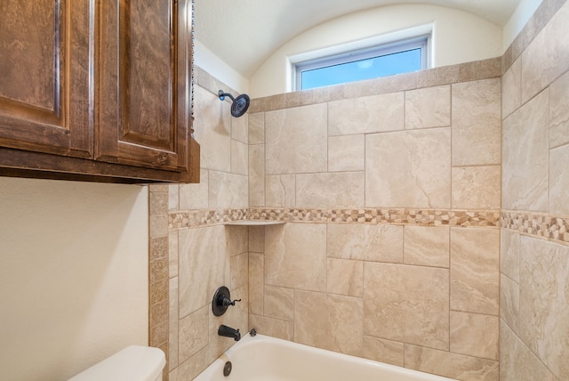 bathroom featuring toilet and tiled shower / bath