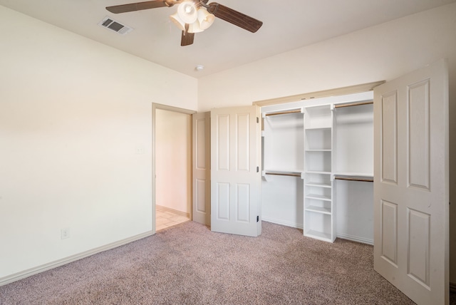 unfurnished bedroom with light colored carpet, ceiling fan, and a closet