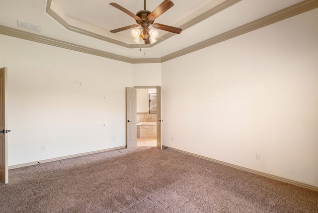 carpeted empty room featuring a raised ceiling, ornamental molding, and ceiling fan