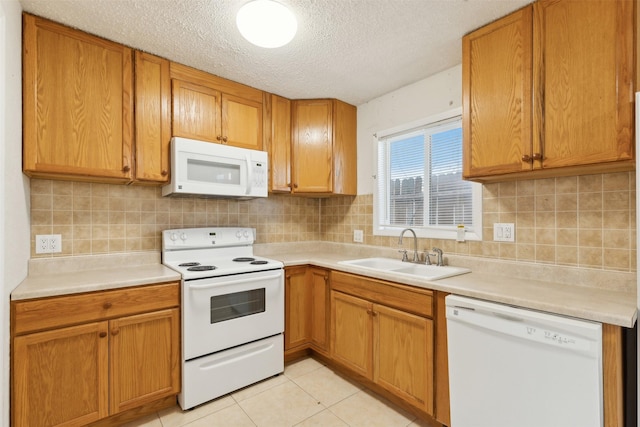 kitchen with sink, backsplash, a textured ceiling, white appliances, and light tile patterned flooring