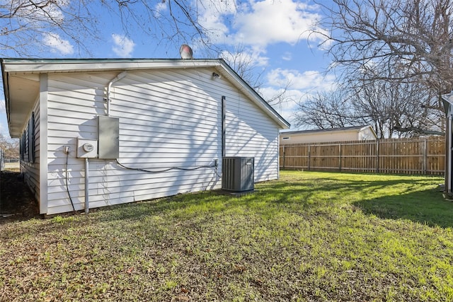 view of side of home featuring a lawn and central AC unit